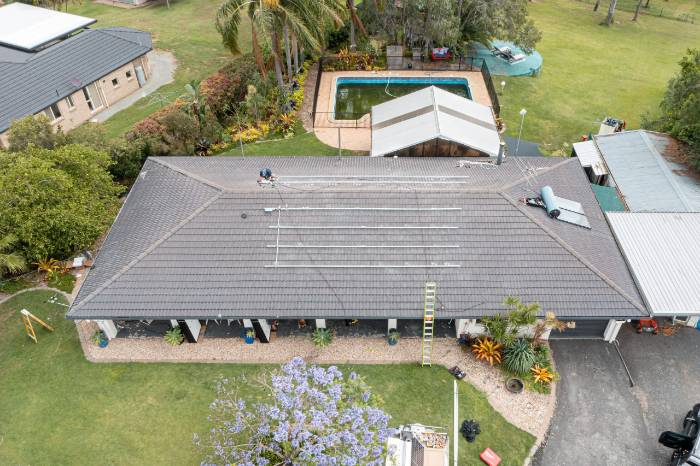 Aerial drone view of a Queensland home with a pool and a newly installed solar array