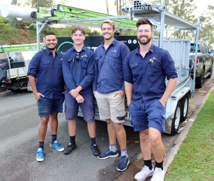 Four Ethos Electrical team members standing together beside their work vehicle