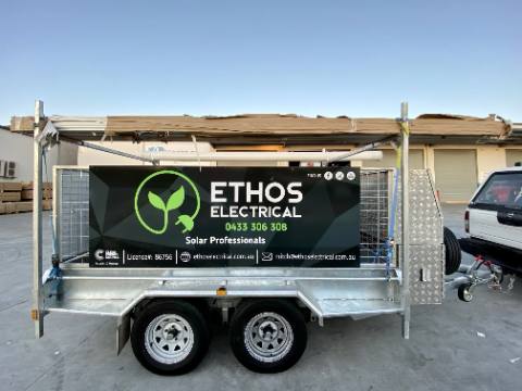 Close-up of the Ethos Electrical logo and contact details signage on a work trailer